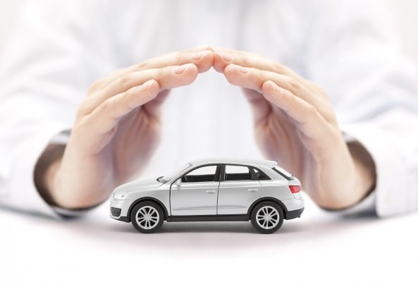 extended car warranty services hands holding protecting toy car  
